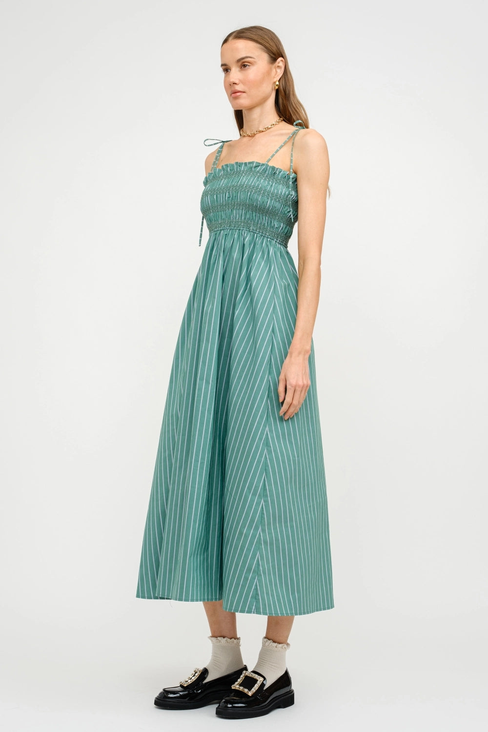 Woman wearing a green striped dress on a white background