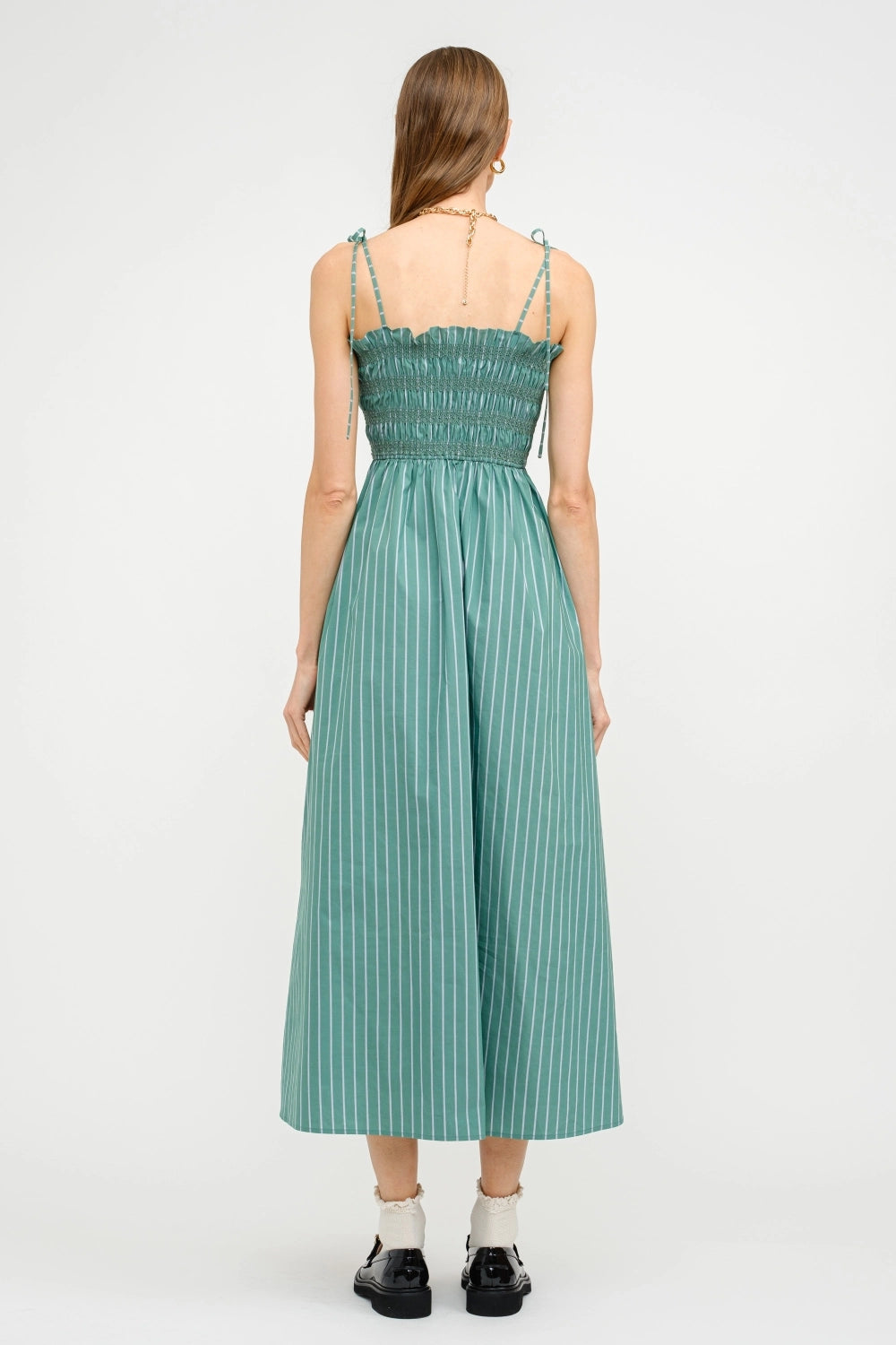 Woman wearing a green striped dress on a white background