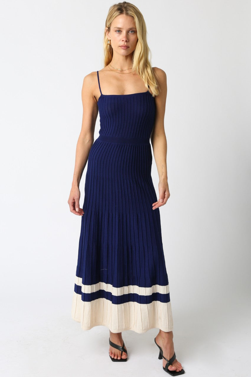 Woman wearing a navy blue and beige dress on a white background