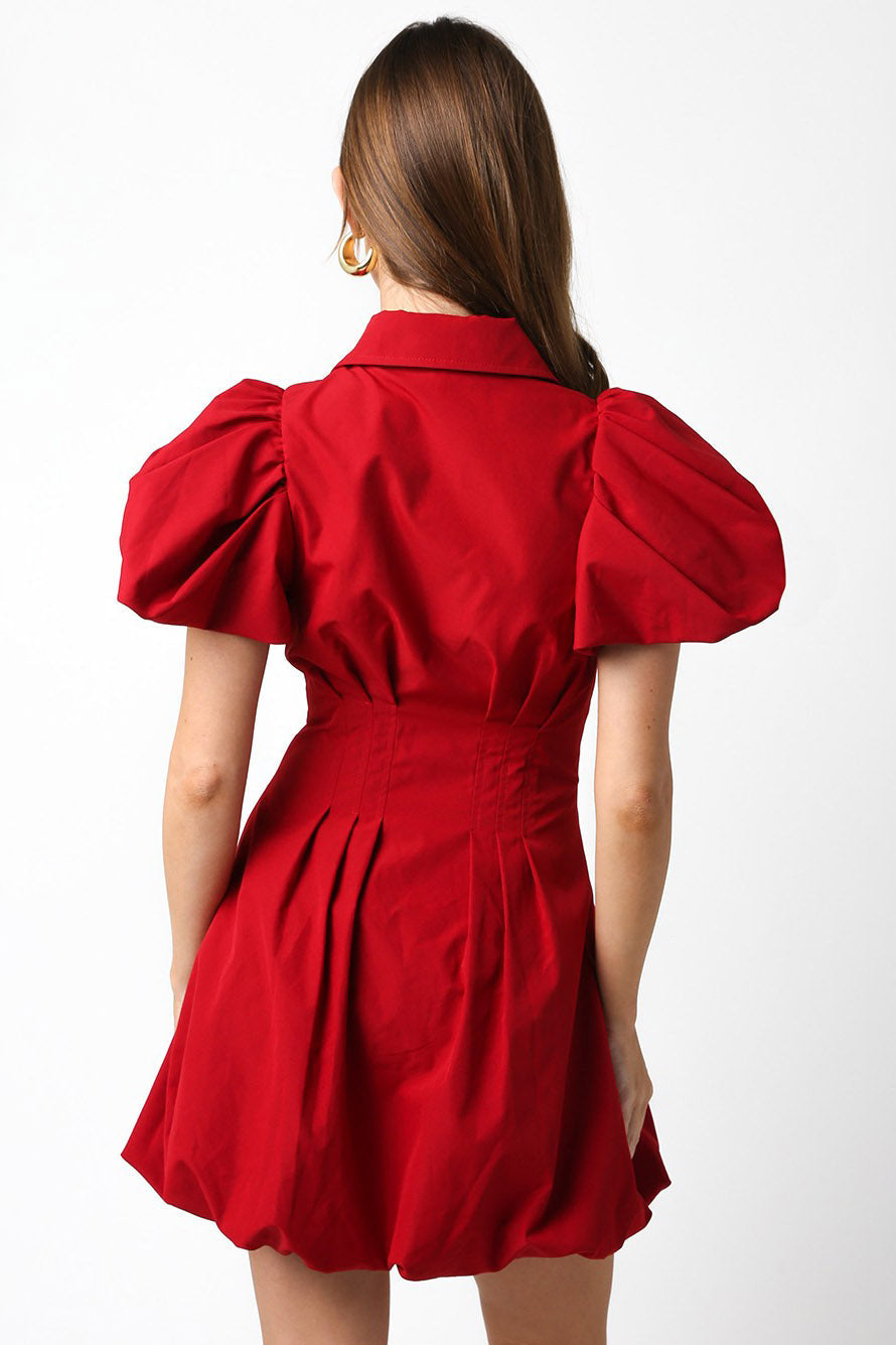 Red dress with puff sleeves worn by a person on a white background