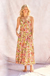 Woman wearing a colorful floral dress against a plain background