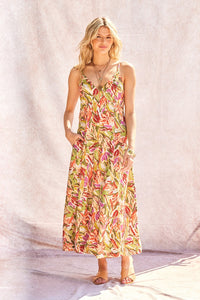 Woman wearing a colorful floral dress against a plain background