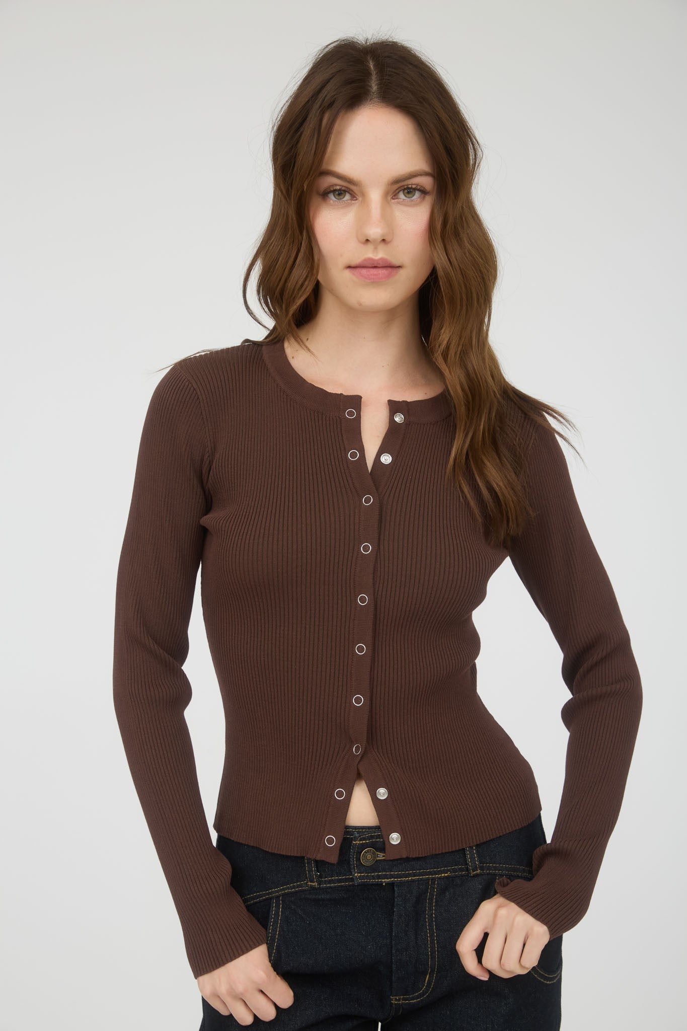 Woman wearing a brown button-up shirt against a white background