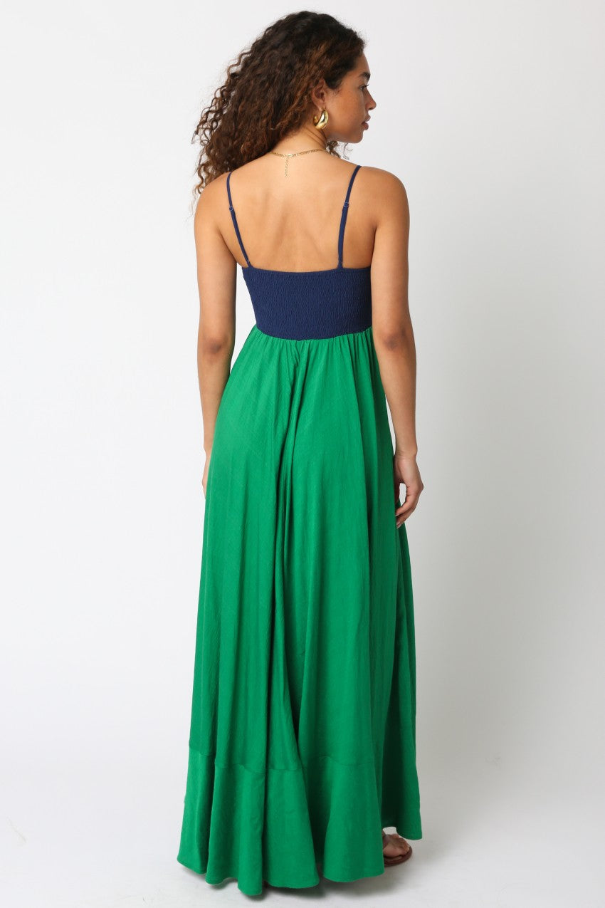 Woman wearing a green and navy dress on a white background