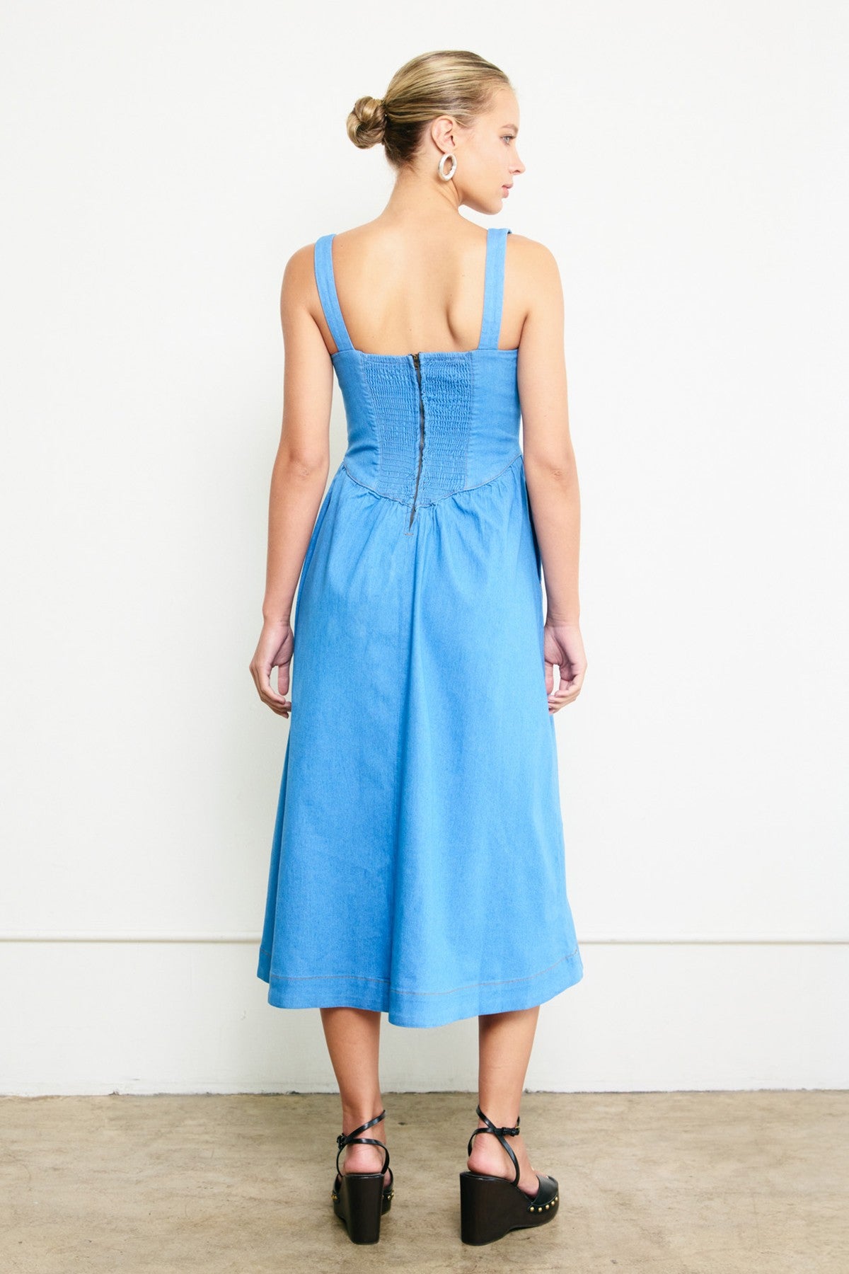 Woman wearing a blue dress with a white background