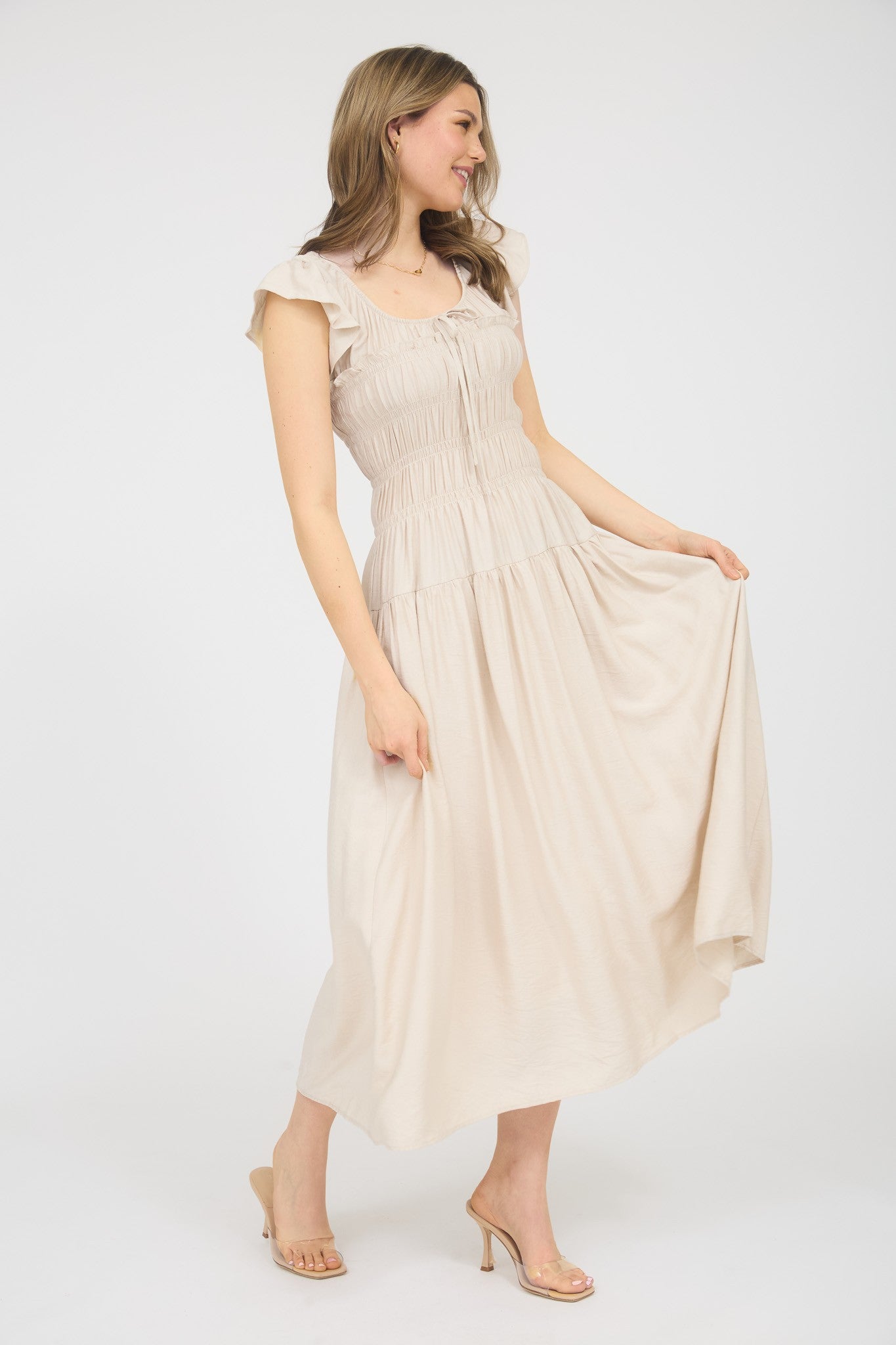 Woman wearing a beige dress on a white background