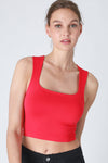 Woman wearing a red tank top against a white background