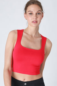 Woman wearing a red tank top against a white background