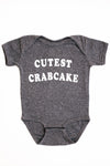 Gray baby onesie with 'CUTEST CRABCAKE' text on a white background