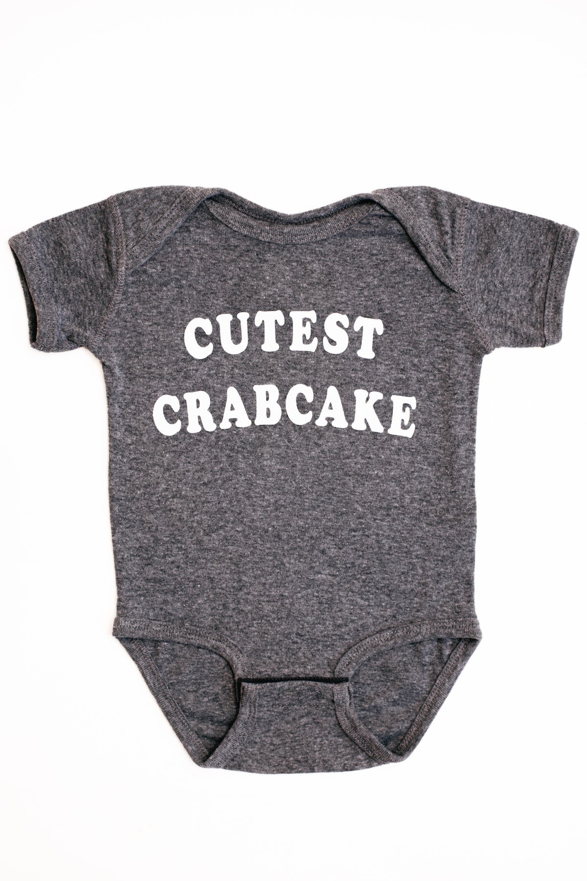 Gray baby onesie with 'CUTEST CRABCAKE' text on a white background