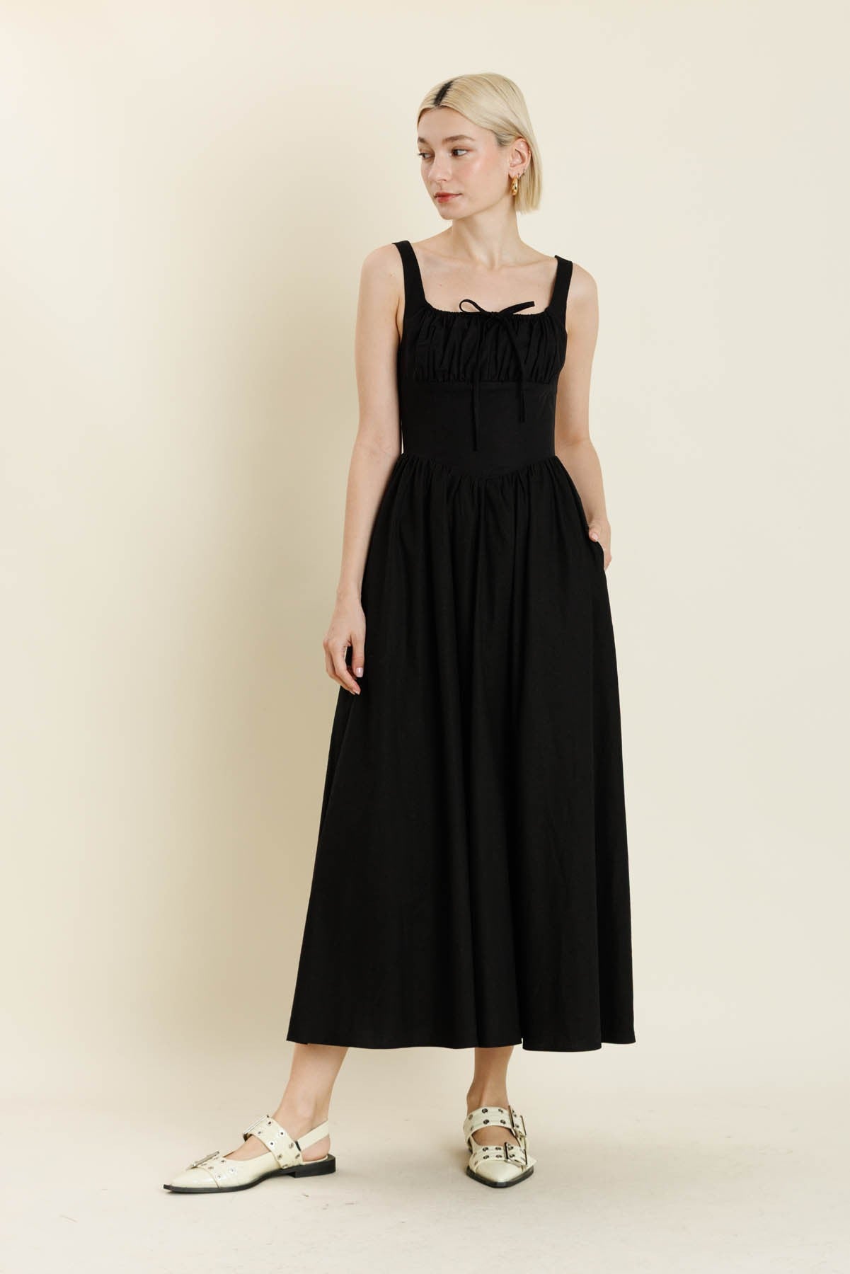 Woman wearing a black dress against a plain background