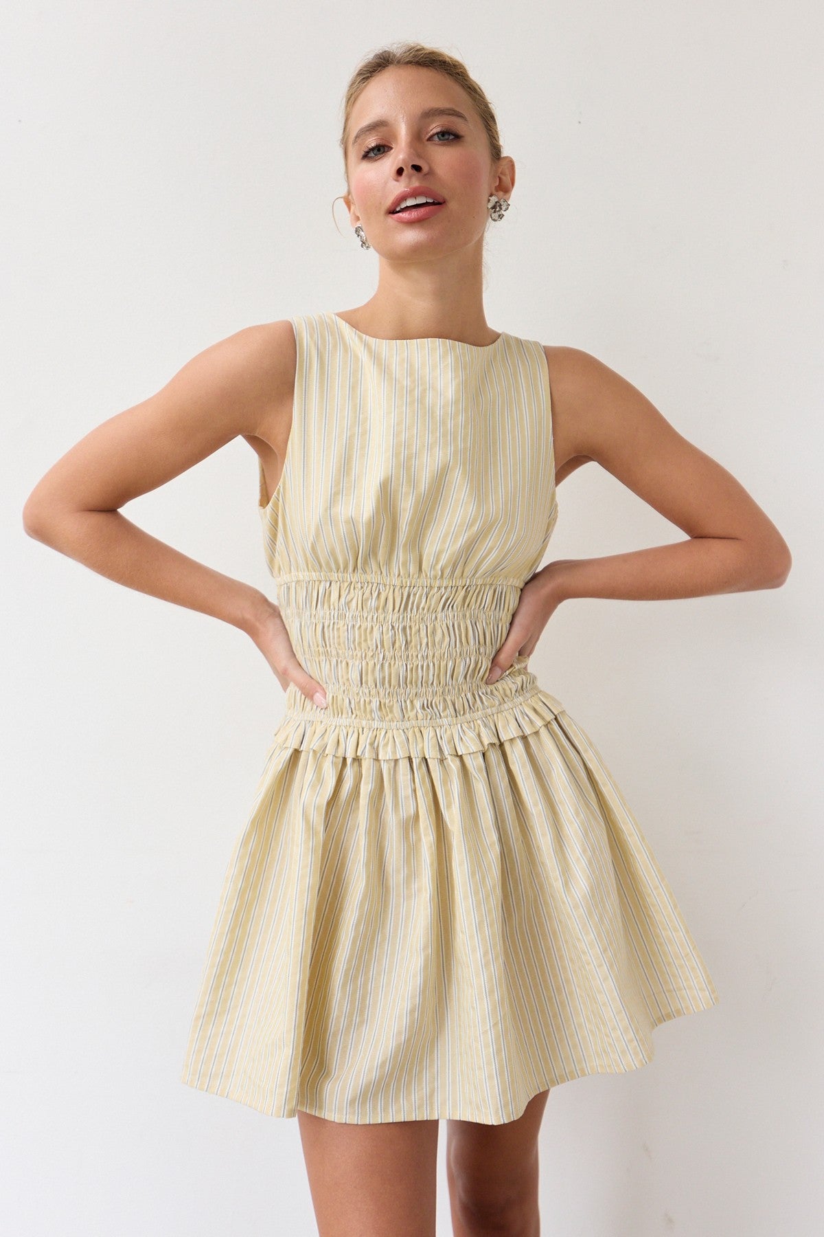 Woman wearing a light yellow dress against a white background